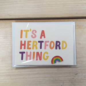 Hannah Bailey It's a Hertford Thing white postcard and enamel pin badge
