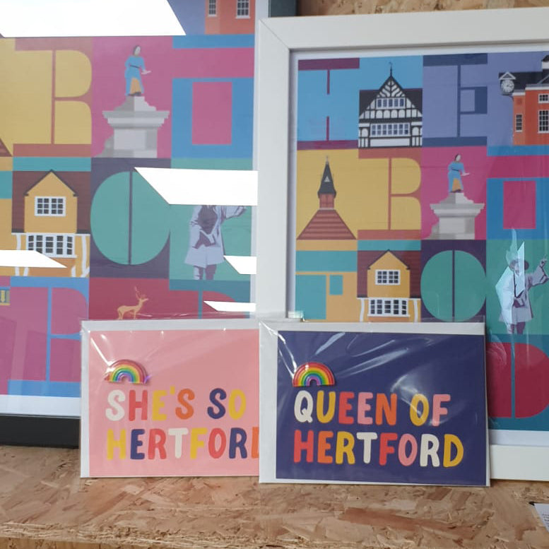 Hannah Bailey Queen of Hertford blue postcard and enamel pin badge displayed